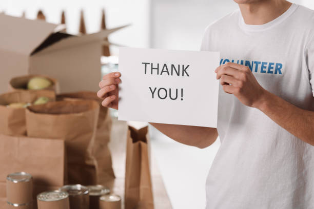 istock volunteer with thank you placard 901237048