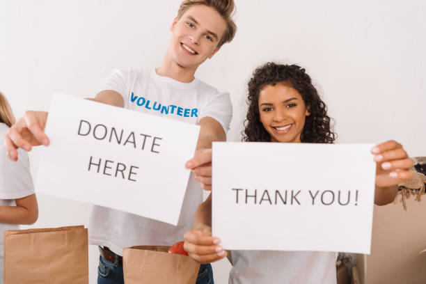 istock volunteers holding charity placards 901239950