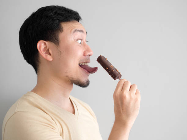 istock Funny face man eat chocolate vanilla ice pop. 901240802