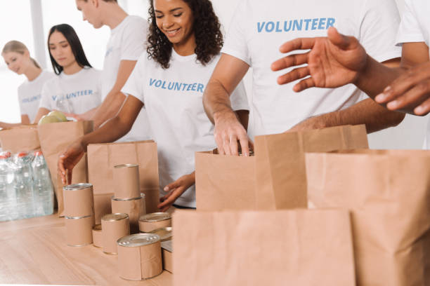 istock volunteers putting food and drinks into bags 901244476