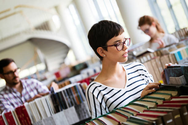 istock Woman reading a book at the library 901256204
