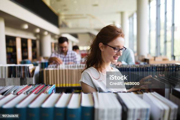 Porträt Eines Ziemlich Lächelndes Mädchen Lesen Buch In Bibliothek Stockfoto und mehr Bilder von Bibliothek