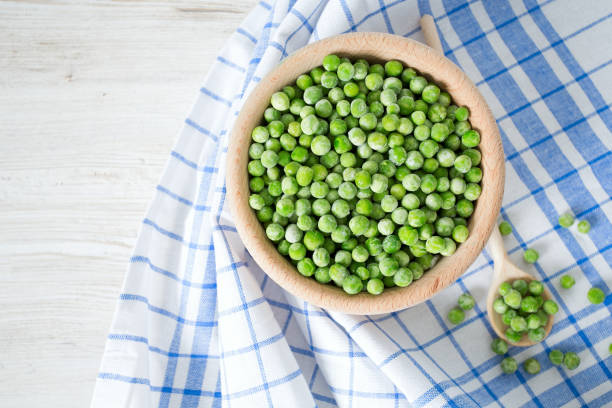 istock frozem peas on wooden surface 901266082