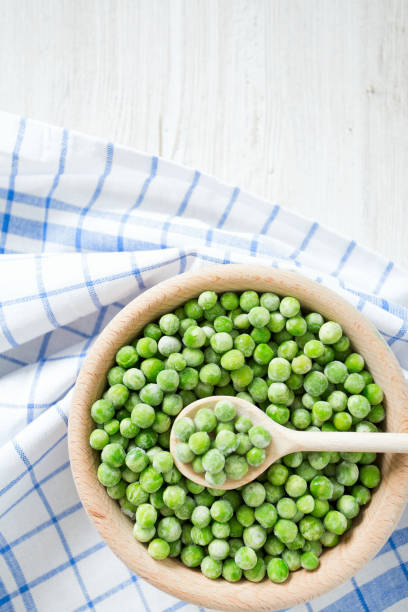 istock frozem peas on wooden surface 901266172