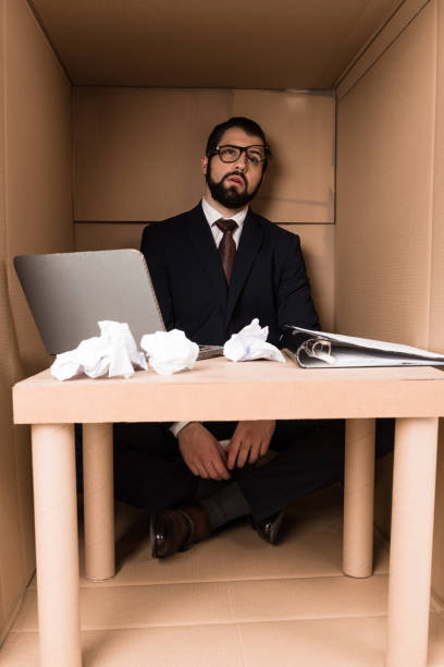 istock exhausted businessman sitting in box 901269338