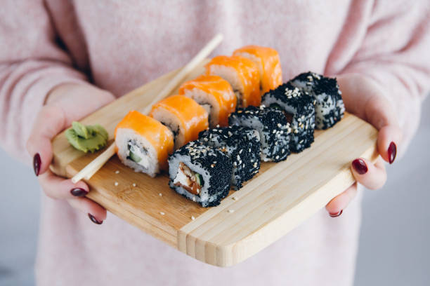 istock Women's hands holding the Board with a Philadelphia roll 901276338