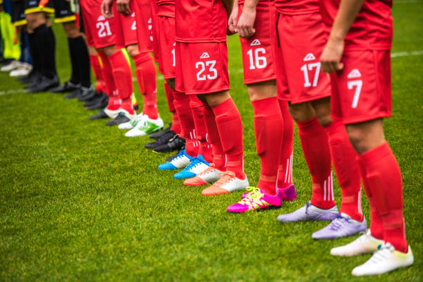 Football players and referees standng in line at start of match Association football (soccer) players standing in a row side by side at the start of the match. football socks stock pictures, royalty-free photos & images