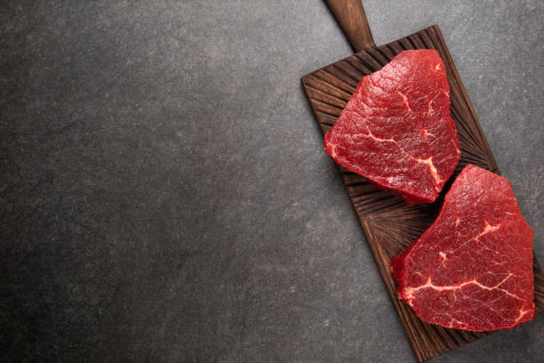 istock Raw meat, beef marbled steak on dark background, top view 901284318