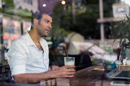 Face Of Handsome Man Drinking Iced Coffee In Coffee Shop While Sitting With Friend Horizontal Shot