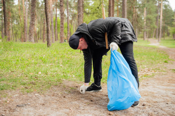 hombre voluntario recogiendo basura en el parque - wastepaper basket fotografías e imágenes de stock