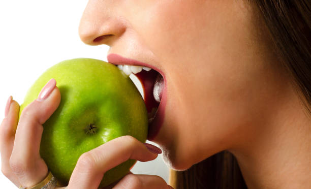 istock woman biting green apple 901296880
