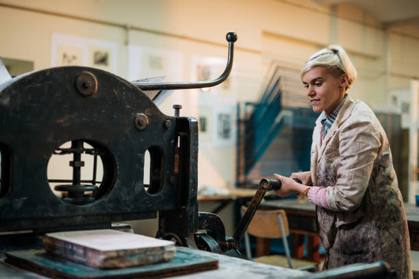 istock Skilled woman using machine for making lithographs for sale 901304266