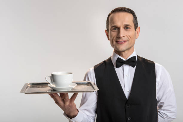 istock Positive male waiter serving coffee 901327056