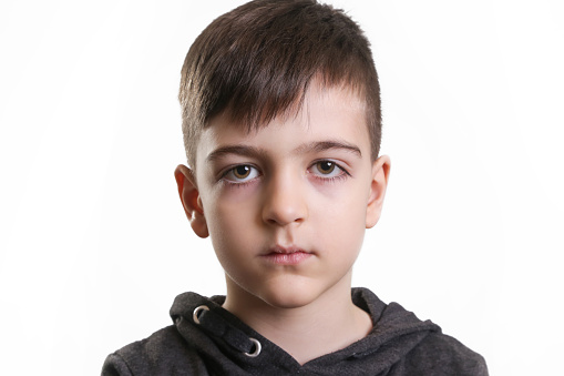 Studio portrait of preschool 5 years old boy on the white background - neutral facial expression