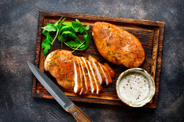 Grilled chicken breast in a sweet and sour marinade Grilled chicken breast in a sweet and sour marinade with yogurt sauce on a wooden cutting board.Top view. Chicken Breast stock pictures, royalty-free photos & images
