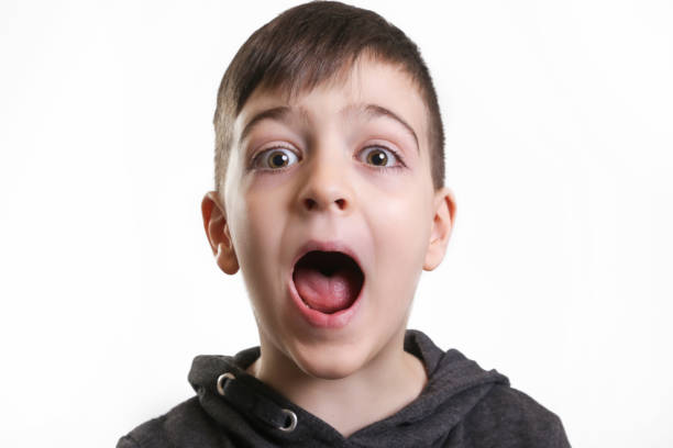 Studio portrait cute boy screaming at the camera Studio portrait cute boy screaming at the camera child laughing hysterically stock pictures, royalty-free photos & images