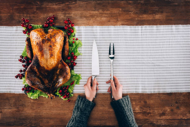 istock Man serving baked turkey and utensils 901349680