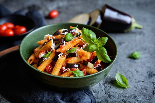 Pasta alla Norma - traditional Italian food with eggplant, tomato, cheese and basil