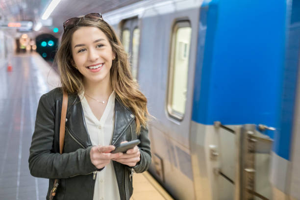 istock Young woman prepares to board subway train 901354478