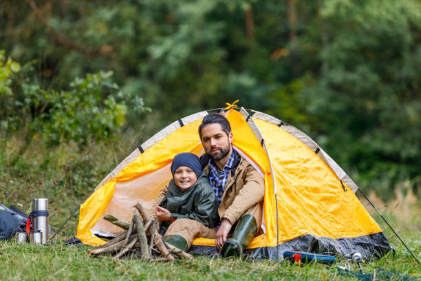 istock father and son sitting in tent 901375330