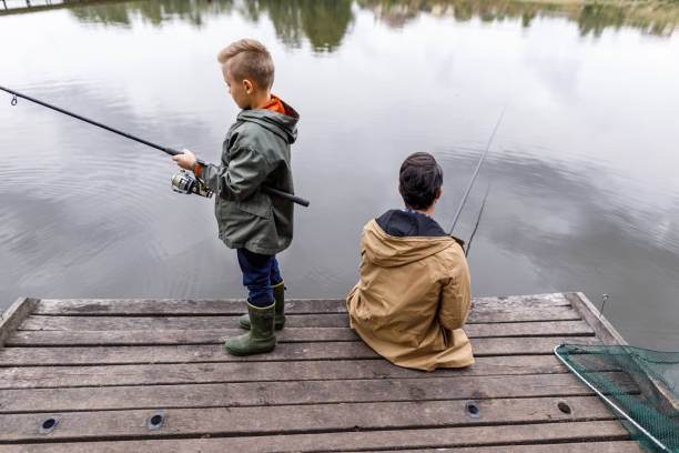 istock father and son fishing with rods 901381784