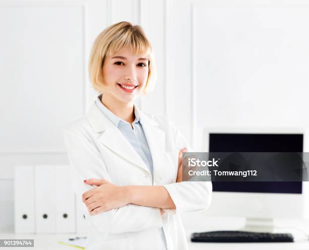 Junger Arzt Mit Weißen Kittel Stehen Im Büro Stockfoto und mehr Bilder von Arzt - Arzt, Arzthelferin, Assistent