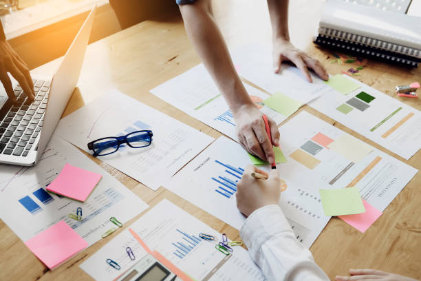 istock Business people using pen pointing graph chart paper of conference and use laptop computer for income & budget of sale in this year. 901398134