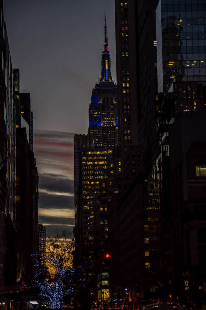 manhattan, new york, 20 dicembre 2017: edifici e empire state building e cielo serale scuro - editorial famous place vertical manhattan foto e immagini stock