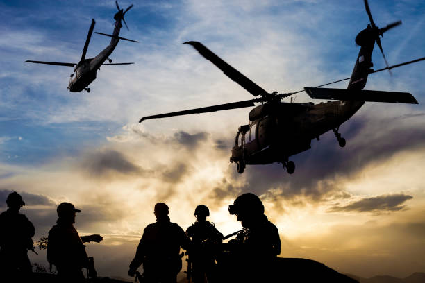 siluetas de soldados durante una misión militar al atardecer - air vehicle audio fotografías e imágenes de stock