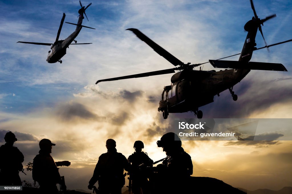 Silhouettes of soldiers during Military Mission at dusk Afghanistan Stock Photo