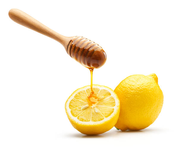 Honey dripping on fresh lemon isolated