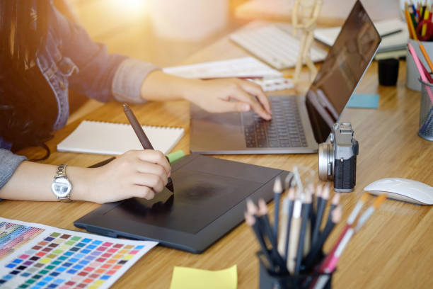 istock Cropped shot of young designer drawing digital tablet and using a laptop for design artwork. 901420870