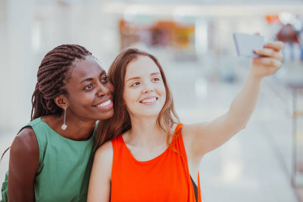 istock Smiling female friends taking selfie indoors 901427610