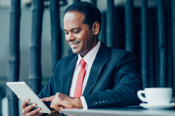 istock Smiling Business Man Working on Tablet in Cafe 901427690