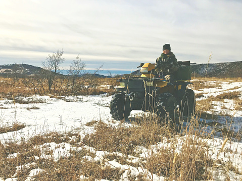 High Altitude Hunting area light snowfall on ground in winter on the Grand Mesa in western Colorado barren oak brush and 4 wheeler ATV couple outdoors - shot with iPhone 7 Plus