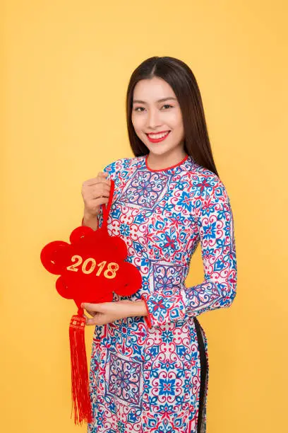 Vietnamese woman traditional festival costume Ao Dai holding attributes. Text mean Happiness.
