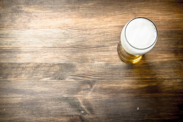 mug of fresh beer. On wooden table.