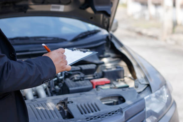 istock Side view of writing on clipboard while insurance agent examining car 901441188