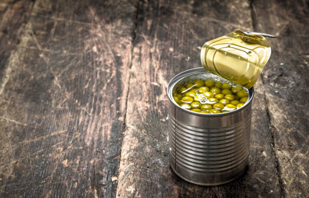 Canned green peas in a tin can. Canned green peas in a tin can. On a wooden background. 2667 stock pictures, royalty-free photos & images