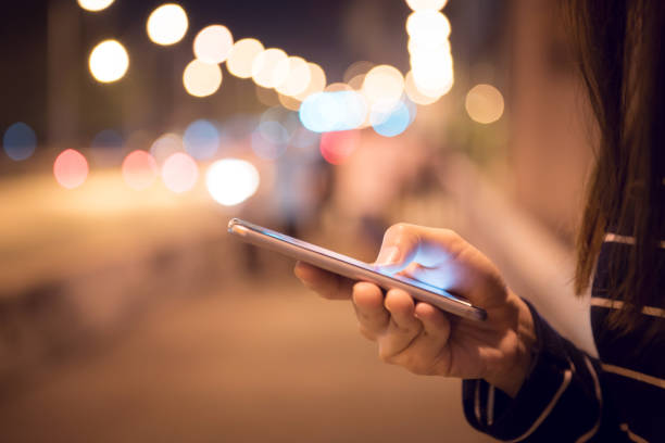 istock Woman using Mobile smartphone in the street, night light bokeh Background, 901441920