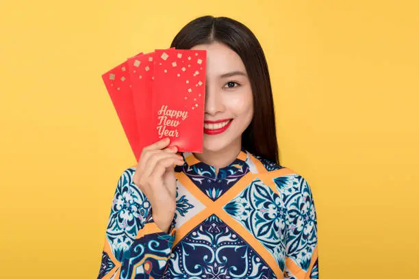 Vietnamese woman traditional festival costume Ao Da holding red money pockets. Tet holiday. Lunar New Year.