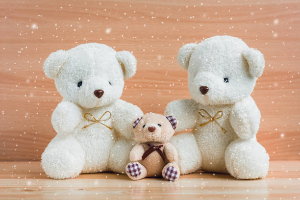 istock Family bears and snow on a wooden background 901448708