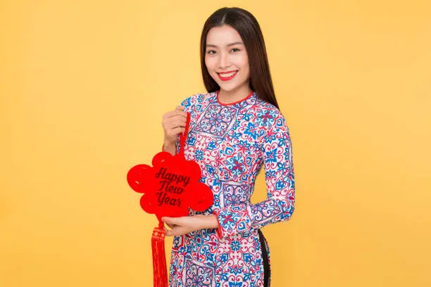 Vietnamese woman traditional festival costume Ao Dai holding attributes. Text mean Happiness.