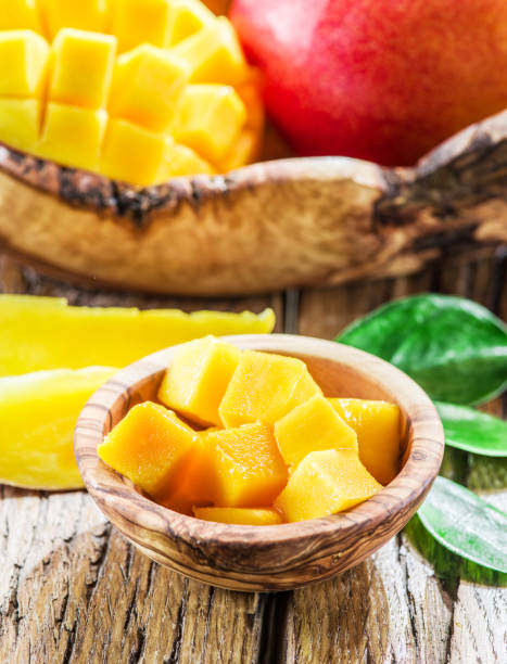 istock Mango fruit and mango cubes on the wooden table. 901449102