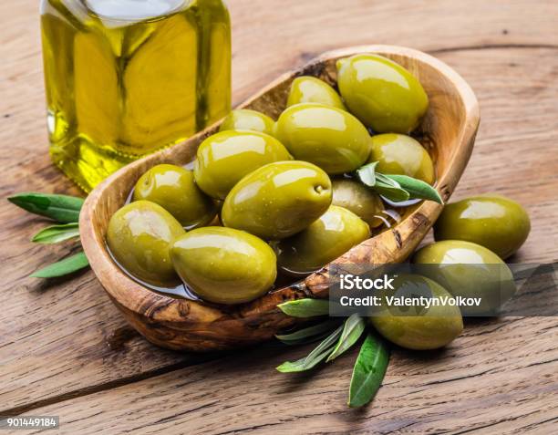 Olive Berries And Bottle Of Olive Oil On The Wooden Table Stock Photo - Download Image Now