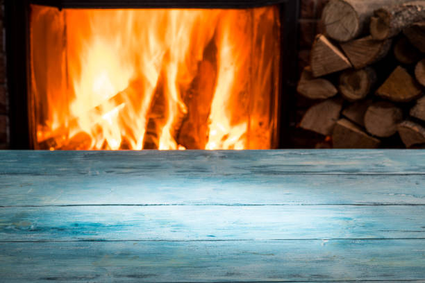 istock Wooden table top and burning warm fire at the background. 901452026