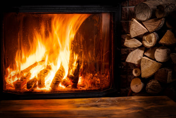istock Old wooden table and fireplace with warm fire at the background. 901452062