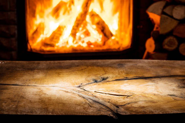 istock Empty wooden table and fireplace with warm fire on the background. 901456722