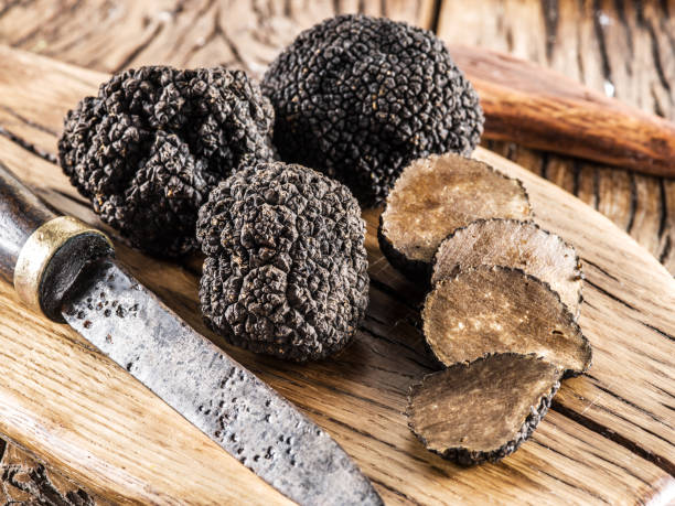 istock Black truffles on the old wooden table. 901468864