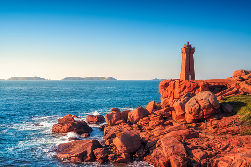 Ploumanach Mean Ruz lighthouse red sunset in pink granite coast, Perros Guirec, Brittany, France